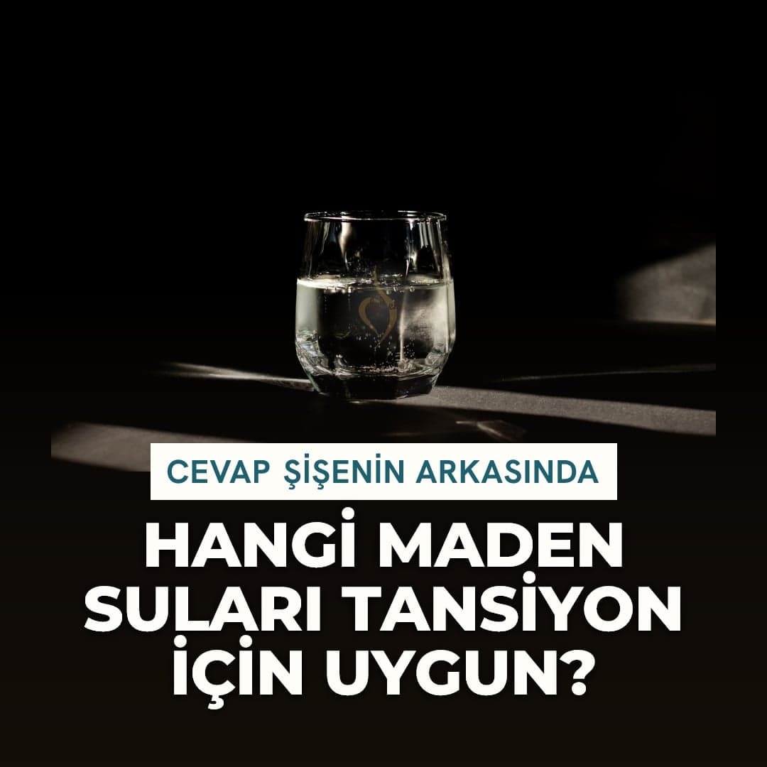 Koyu zeminde, ışık düşen bir yüzeyde duran maden suyu bardağı